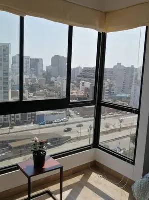 a room with a large window with a view of a city at MODERNO LOFT BARRANCO, VISTA PANORAMICA in Lima