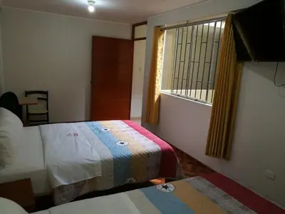a hotel room with two beds and a window at El Sol de Nazca in Nazca