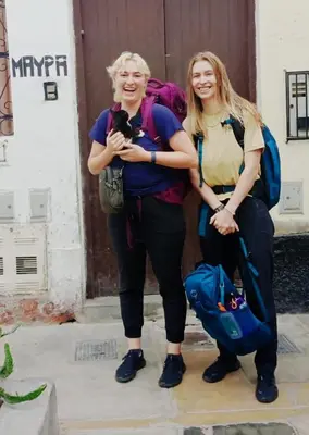 two women standing next to each other with a dog at Maypa Lima Airport in Lima