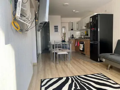 a kitchen and living room with a black refrigerator at Céntrico mini departamento, moderno y acogedor in Lima