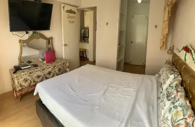 a bedroom with a bed and a tv on the wall at VERSALLES APARTMENT in Lima