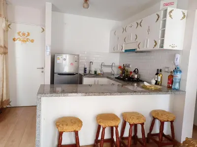 a kitchen with a counter with three stools at VERSALLES APARTMENT in Lima