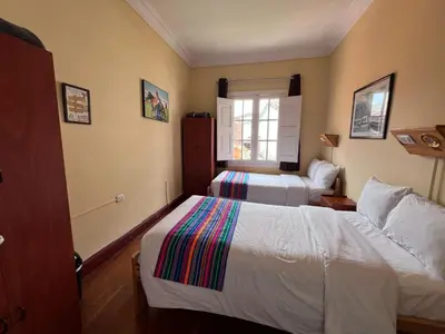 a hotel room with two beds and a window at Eco Inn in Cusco