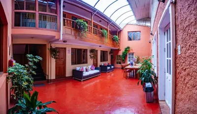 an indoor courtyard with a couch and a table in a building at Eco Inn in Cusco