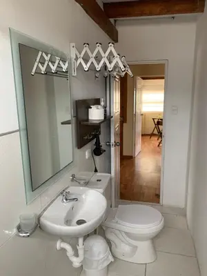 a bathroom with a sink and a toilet and a mirror at Apartamento zona histórica Barranco Desayuno incluido in Lima