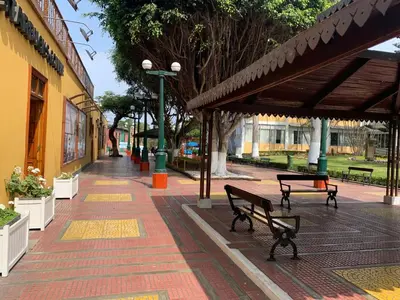 an empty sidewalk with benches and awning in a park at Apartamento zona histórica Barranco Desayuno incluido in Lima