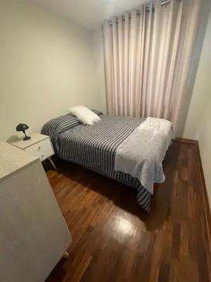 a small bedroom with a bed and a window at Departamento completo en Miraflores Surquillo in Lima