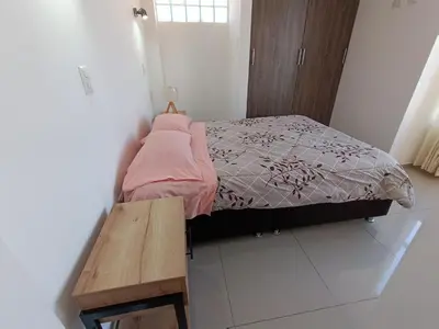 a small bedroom with a bed and a wooden table at III Zaguan Aparta Hotel Cusco in Cusco