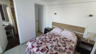 a bedroom with a bed with a quilt on it at III Zaguan Aparta Hotel Cusco in Cusco