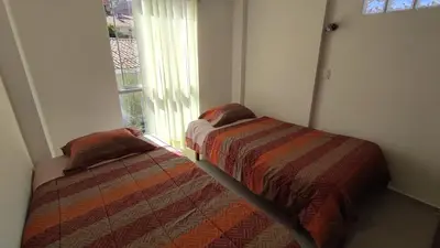 two beds sitting next to a window in a room at III Zaguan Aparta Hotel Cusco in Cusco
