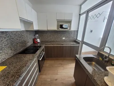 a kitchen with granite counter tops and a sink at Espacio Luxury Apartments - Malecón 28 de Julio. in Lima