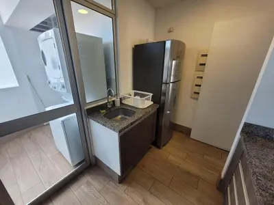 a kitchen with a sink and a refrigerator at Espacio Luxury Apartments - Malecón 28 de Julio. in Lima