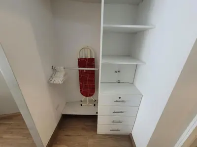 a walk in closet with white shelves and white cabinets at Espacio Luxury Apartments - Malecón 28 de Julio. in Lima