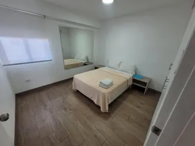 a small bedroom with a bed and a mirror at Espacio Luxury Apartments - Malecón 28 de Julio. in Lima