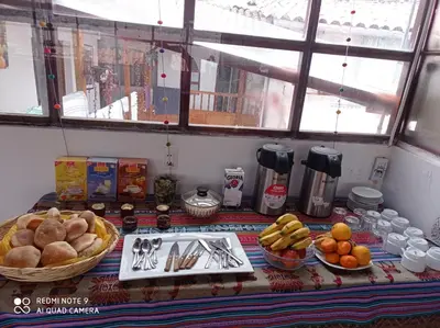 a table with bread and other foods on it at Hostel mágico San Blas in Cusco