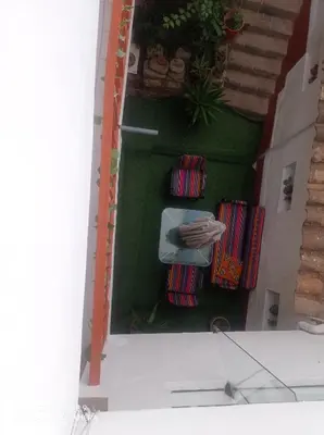a doll house with stairs and a green wall at Hostel mágico San Blas in Cusco