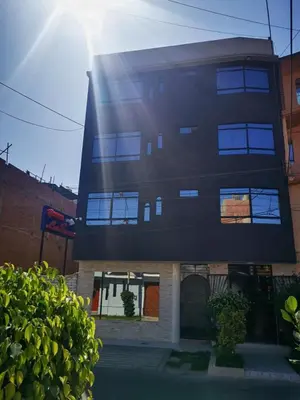 a tall black building with the sun behind it at Los Sauces in Huacho