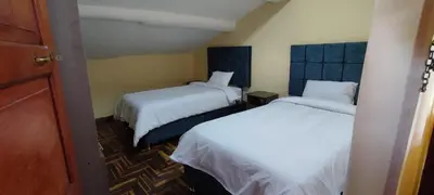 two beds in a small room with twoermottermott at Cusco Hawka Pacha hostal in Cusco