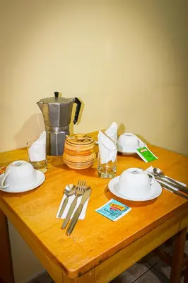 a wooden table with plates and utensils on it at Cusco Hawka Pacha hostal in Cusco