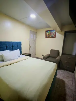 a bedroom with a large bed and a chair at Cusco Hawka Pacha hostal in Cusco