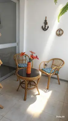 a room with two chairs and a table with a vase at Departamentos Cerro Azul P2 in Cerro Azul