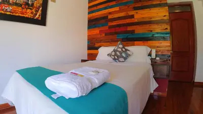 a bedroom with a bed with a wooden wall at Sumaq Wari Hotel in Ayacucho