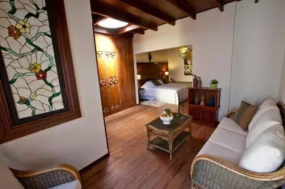a living room with a couch and a bedroom at Hotel & Hacienda El Carmelo in Ica