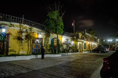 a man standing in front of a building at night at Hotel & Hacienda El Carmelo in Ica