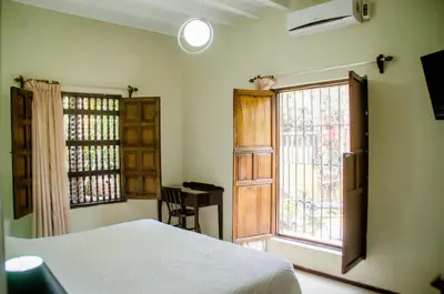 a bedroom with a bed and a large window at Hotel & Hacienda El Carmelo in Ica