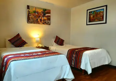 a hotel room with two beds and a picture on the wall at Hotel Santa Maria in Cusco