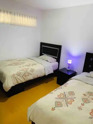 a bedroom with two beds and a lamp on a table at Lovely two bedroom apartment in Miraflores in Lima