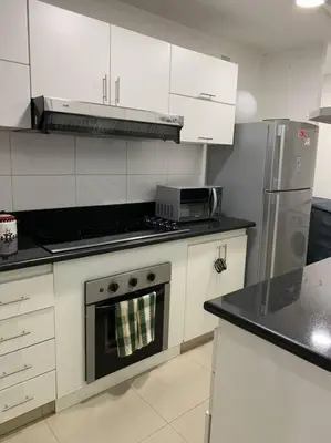 a kitchen with white cabinets and a stove top oven at Lovely two bedroom apartment in Miraflores in Lima