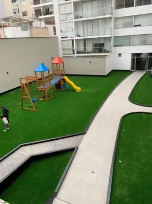an apartment with a playground with a dog on the grass at Lovely two bedroom apartment in Miraflores in Lima