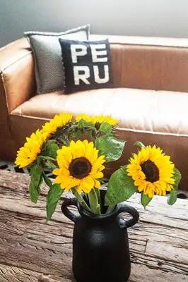 a black vase with yellow flowers on a table at WasiPai Boutique Hotel in Lima