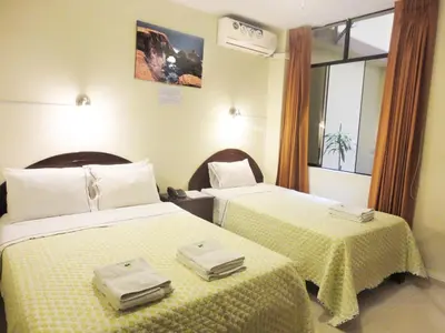 a hotel room with two beds and a window at Hotel Torontel in Ica