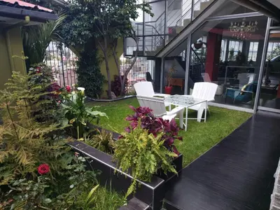 a patio with two white chairs and some plants at Casalos Hotel & Spa in Huancayo