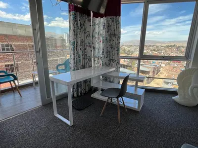a desk and chair in a room with a large window at Casalos Hotel & Spa in Huancayo