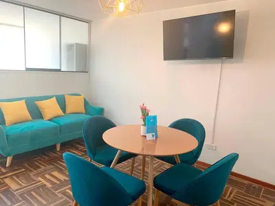 a living room with a table and chairs and a couch at Pershing lindo dpto amoblado 2dorm y wifi in Lima