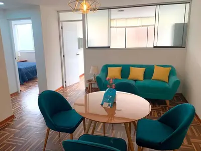 a living room with a couch and a table and chairs at Pershing lindo dpto amoblado 2dorm y wifi in Lima