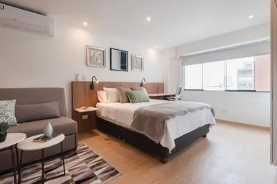a bedroom with a bed and a couch at ALU Apartments - Miraflores in Lima