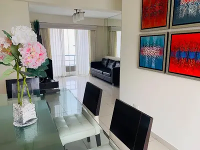 a dining room with a glass table with flowers on it at Spacious apartment in Miraflores in Lima
