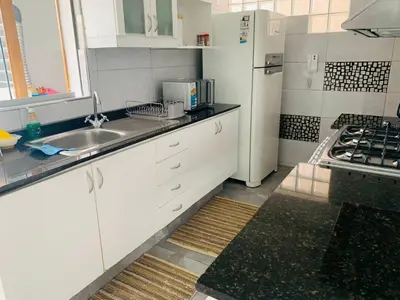 a white kitchen with a sink and a refrigerator at Spacious apartment in Miraflores in Lima