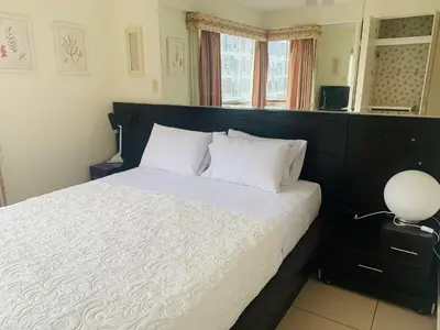 a bedroom with a bed with white sheets and a lamp at Spacious apartment in Miraflores in Lima