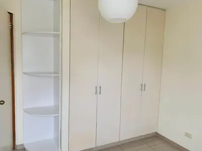 a white kitchen with white cabinets and a light fixture at Spacious apartment in Miraflores in Lima