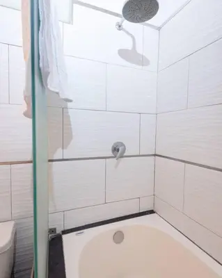 a white bathroom with a shower with a toilet at Sweet MATERNITY Home & 3 dormitorios, AIRE ACONDICIONADO in Lima