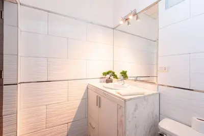 a white bathroom with a sink and a mirror at Sweet MATERNITY Home & 3 dormitorios, AIRE ACONDICIONADO in Lima