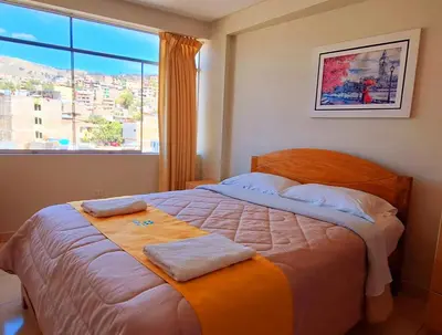 a bedroom with a bed with two towels on it at Illari Wari II-Hotel Sauna in Ayacucho