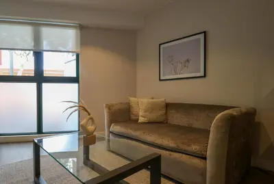 a living room with a couch and a glass table at Monumental by Wynwood House in Lima