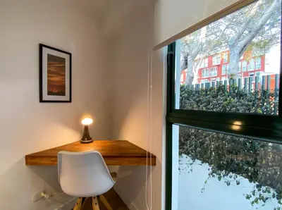 a desk and a chair next to a window at Monumental by Wynwood House in Lima
