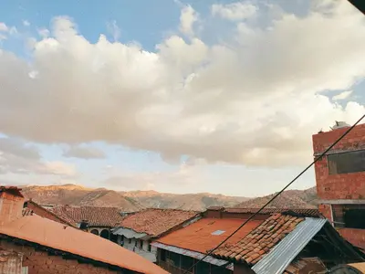 a view of roofs of buildings with mountains in the background at ENEDE HOSTEL in Cusco